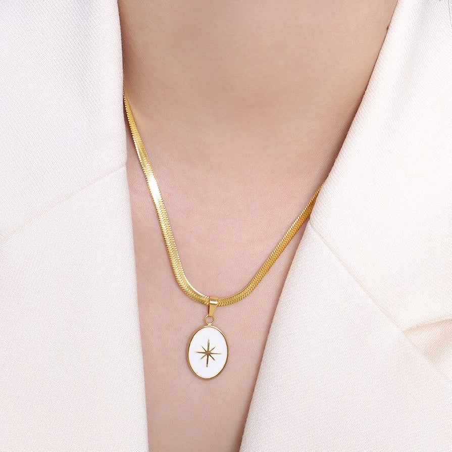 Gold Snake Chain Necklace hanging on a woman's neck with a white jacket.