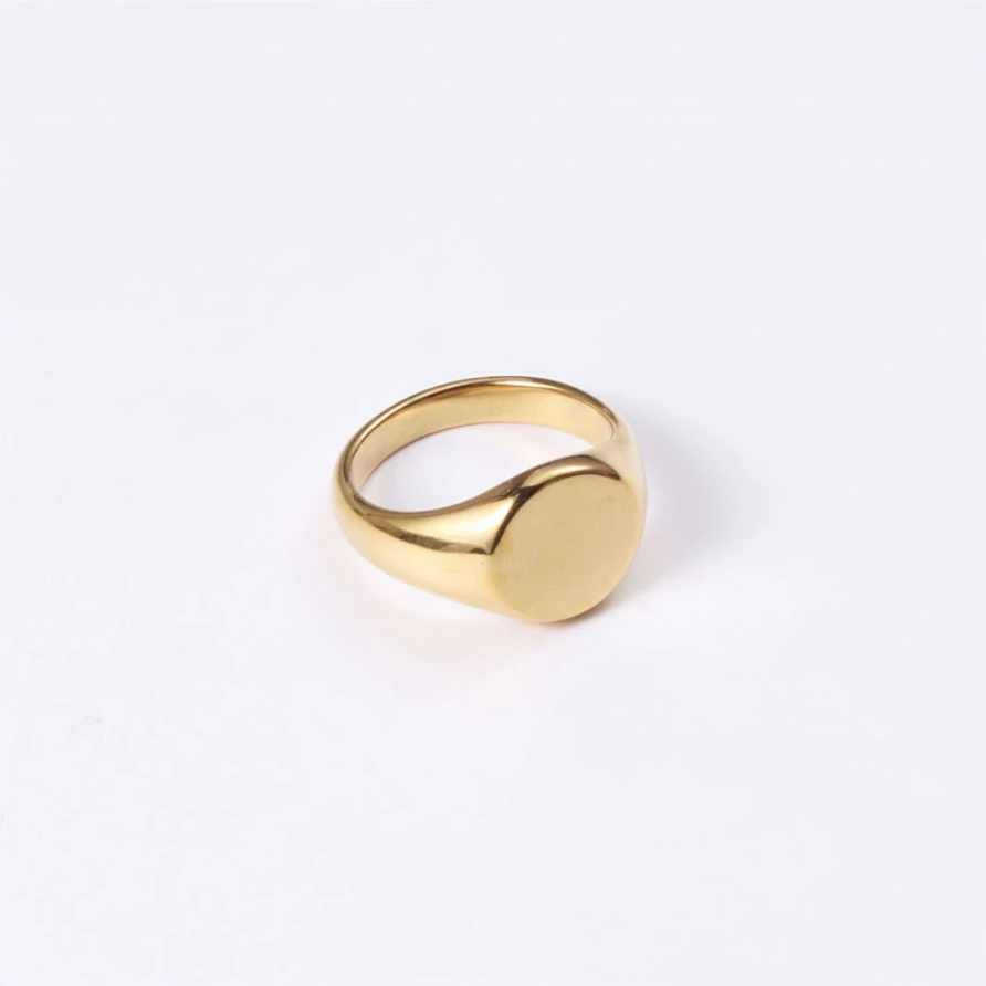 A gold signet ring with a round disc featuring an image or design, worn as a symbol of status or affiliation.