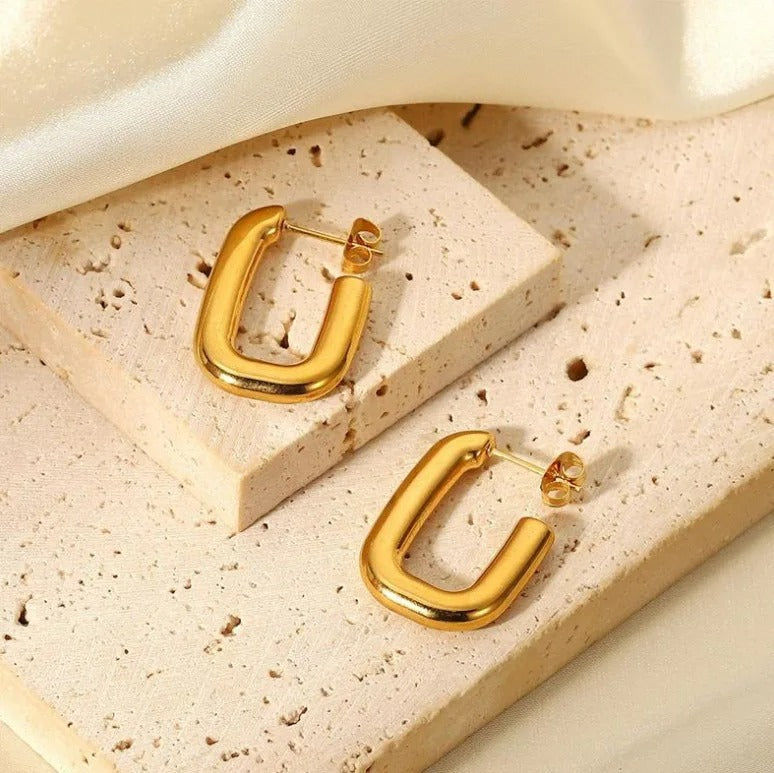 Gold Cut Link Earrings staged onto a sandstone background.