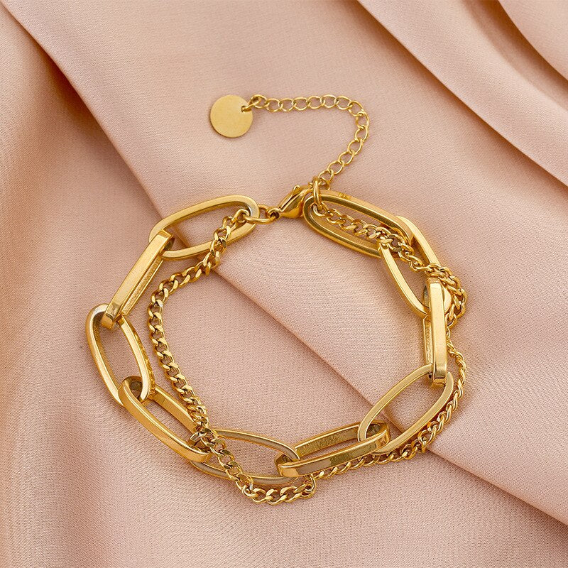 Gold Double Layer Chain Link Bracelet on pink fabric surface.