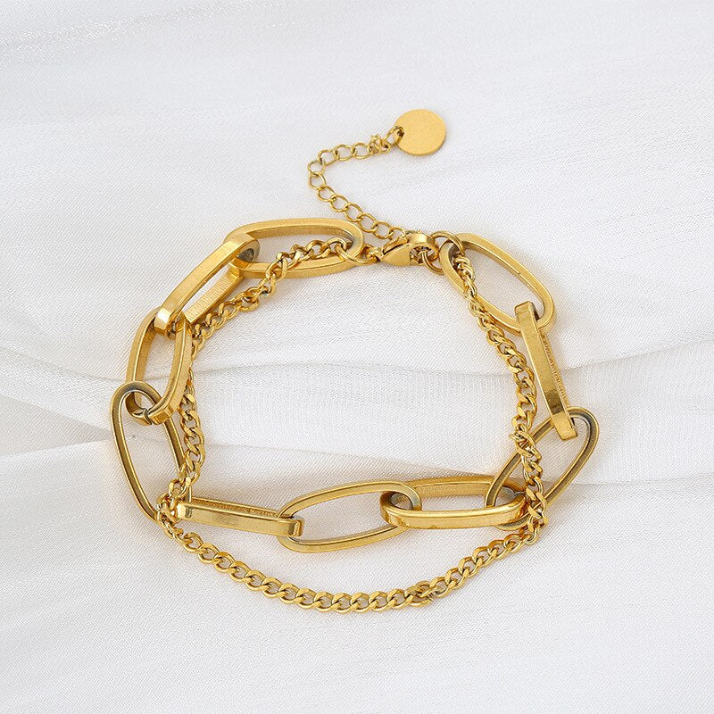 Gold Double Layer Chain Link Bracelet on white fabric background.