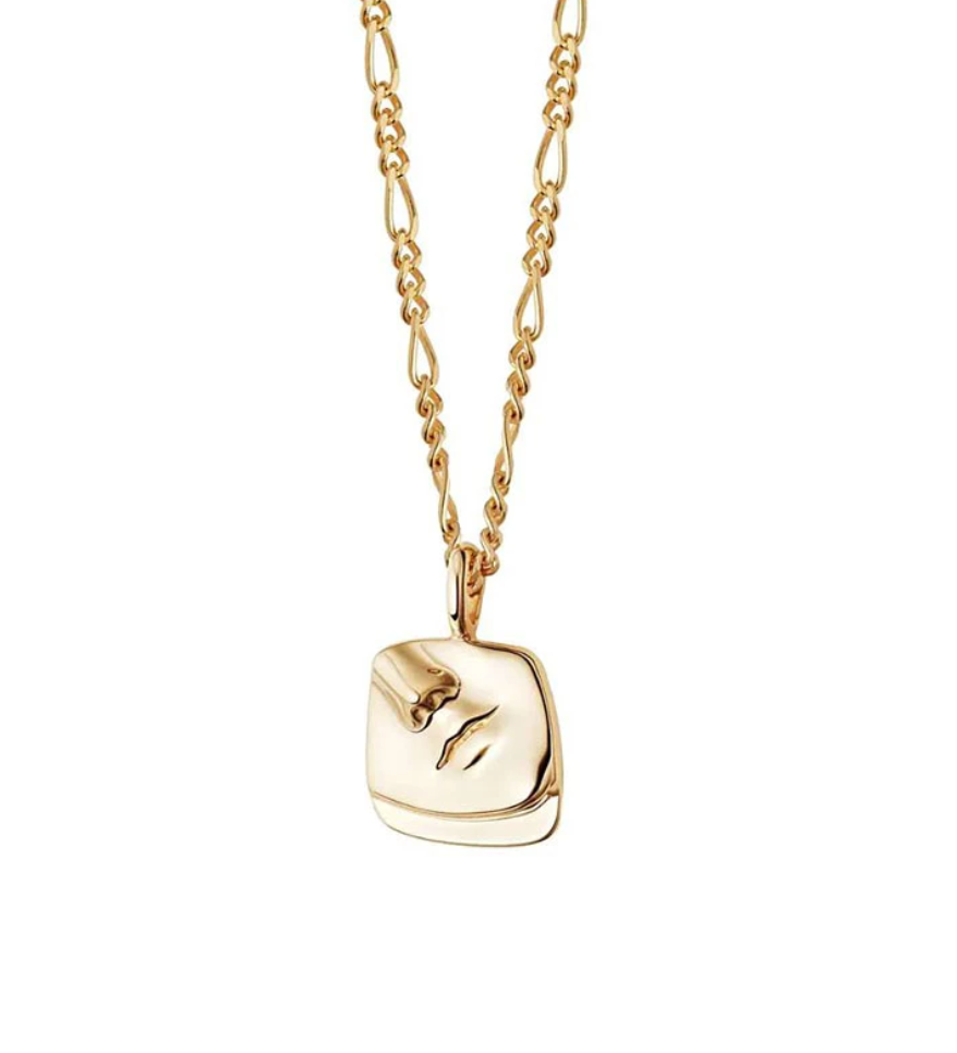 A Gold Femme Face Pendant Necklace hanging on a white background.