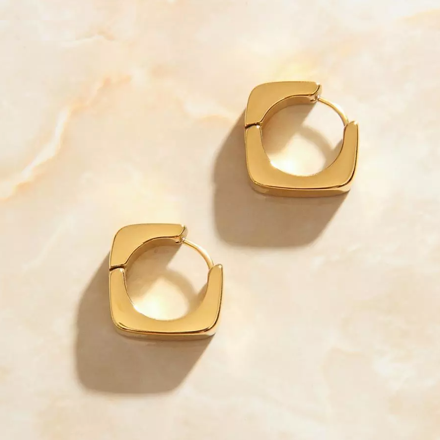 Overhead photo of Gold Geo Square Earrings laying on a rose quartz surface.