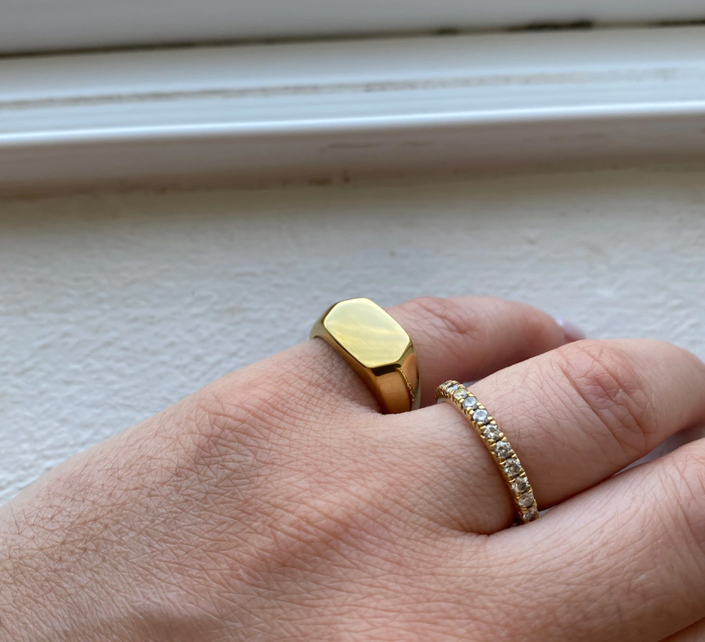 A hand holding a hexagon gold ring that is shining brightly, symbolizing love and commitment.