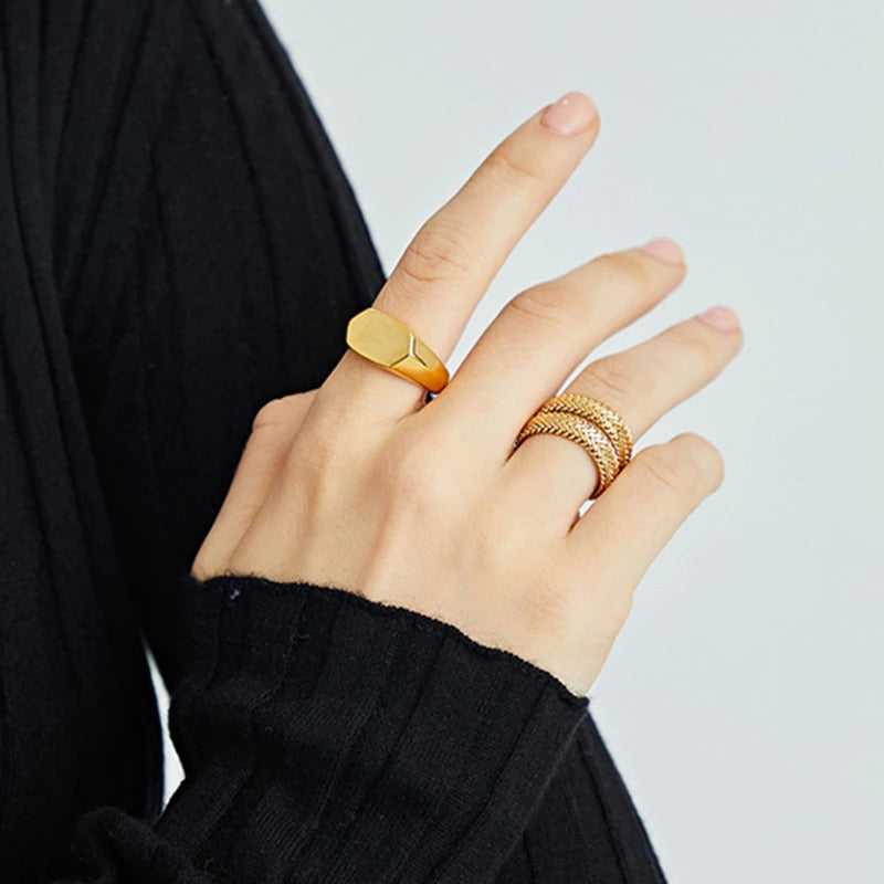 A woman's hand with a minimal gold ring on her finger, showcasing elegance and sophistication.