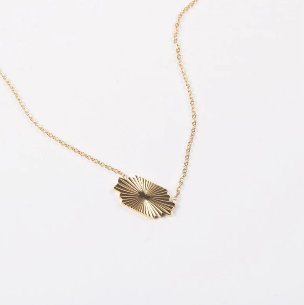 A Gold Horizontal Sunburst Pendant Necklace laid on a white background.