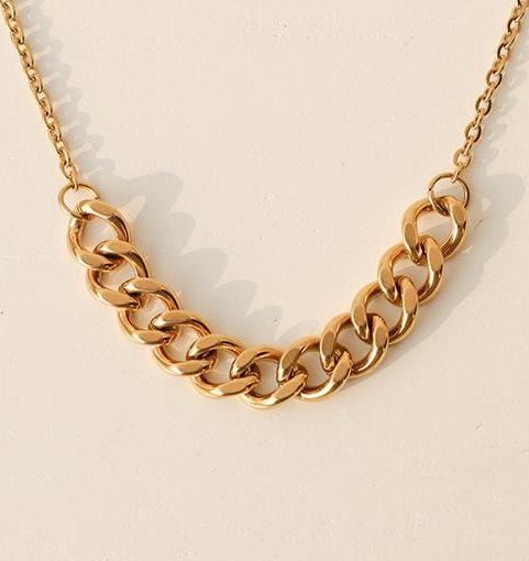 A stunning Gold Mid Chain Necklace shown shining over a plain neutral background.