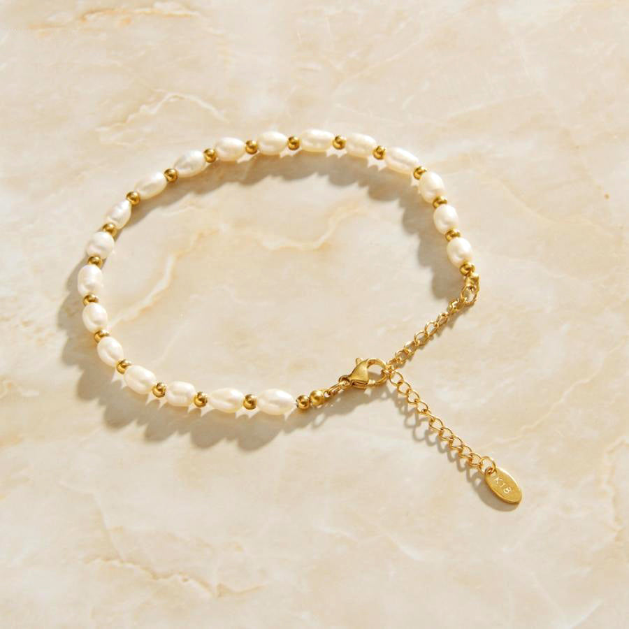 Gold Freshwater Pearl Chain Link Bracelet sitting on top of a smooth quartz surface.
