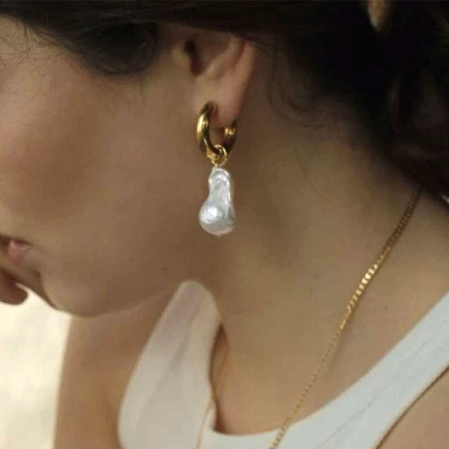 Gold Pearl Hoop Earrings being worn by a woman with dark hair.