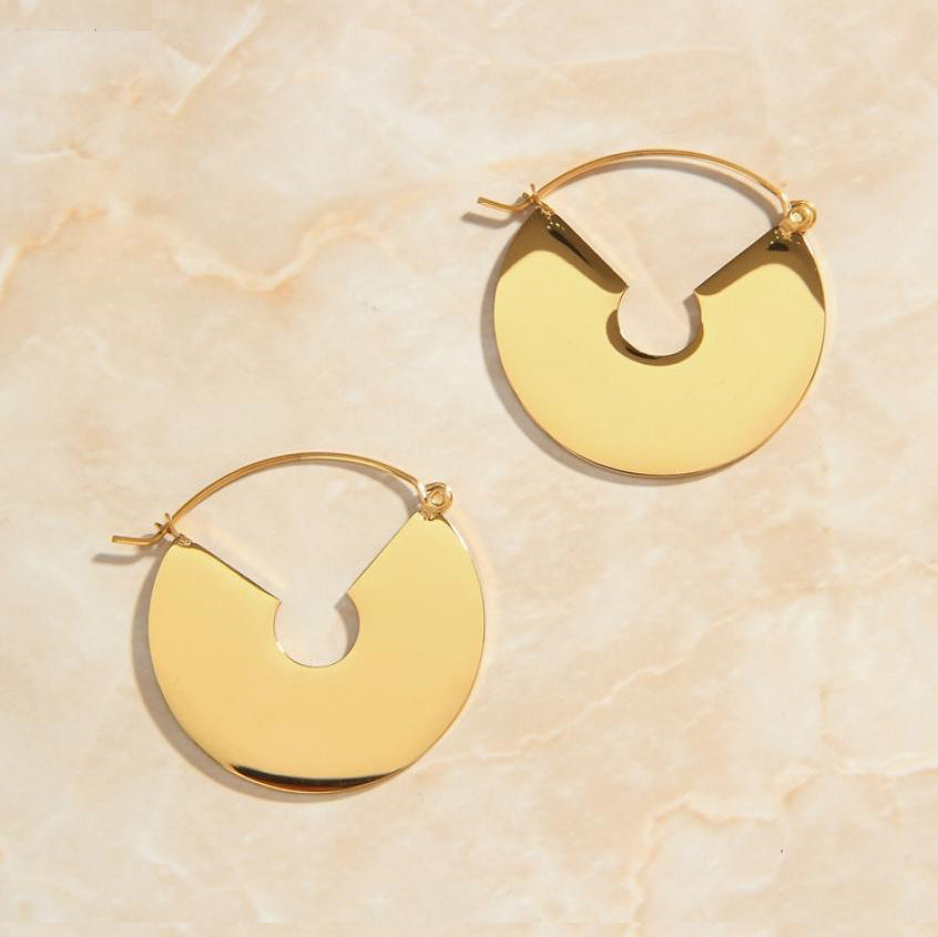 Gold Smooth Fan Drop Earrings laying on a smooth rose quartz surface shining brightly.