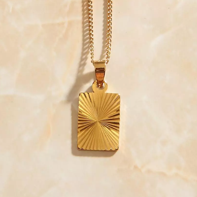 A closeup view of the sunburst necklace pendant with simple chain.