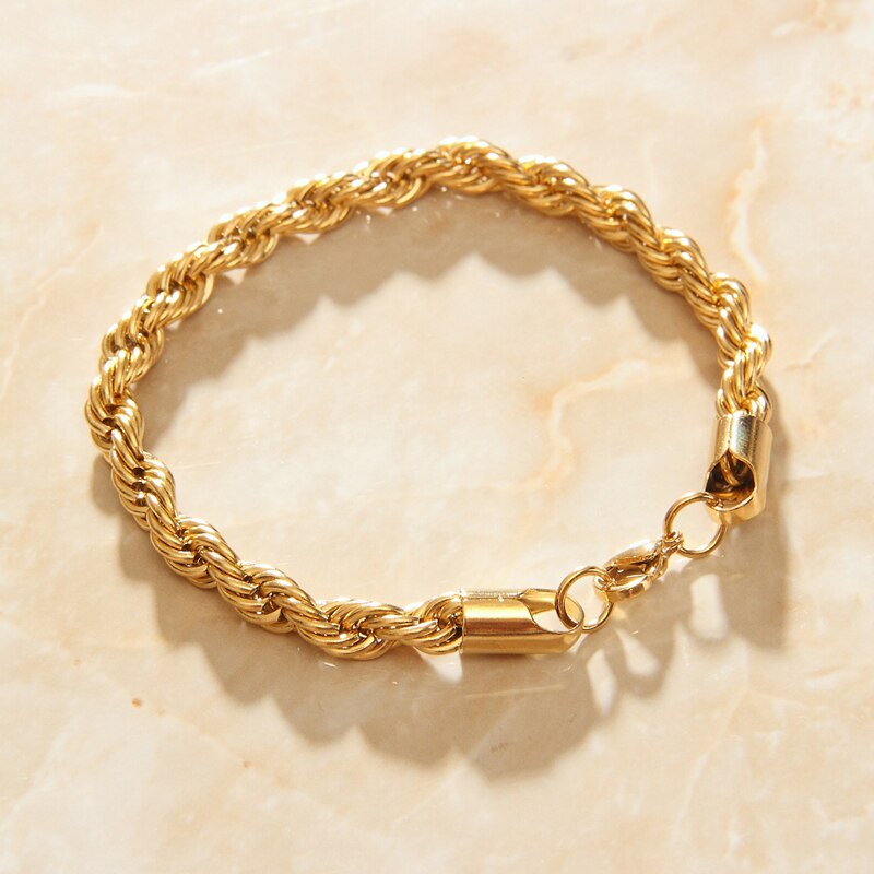 Gold Thick Rope Chain Link Bracelet on a smooth quartz surface.