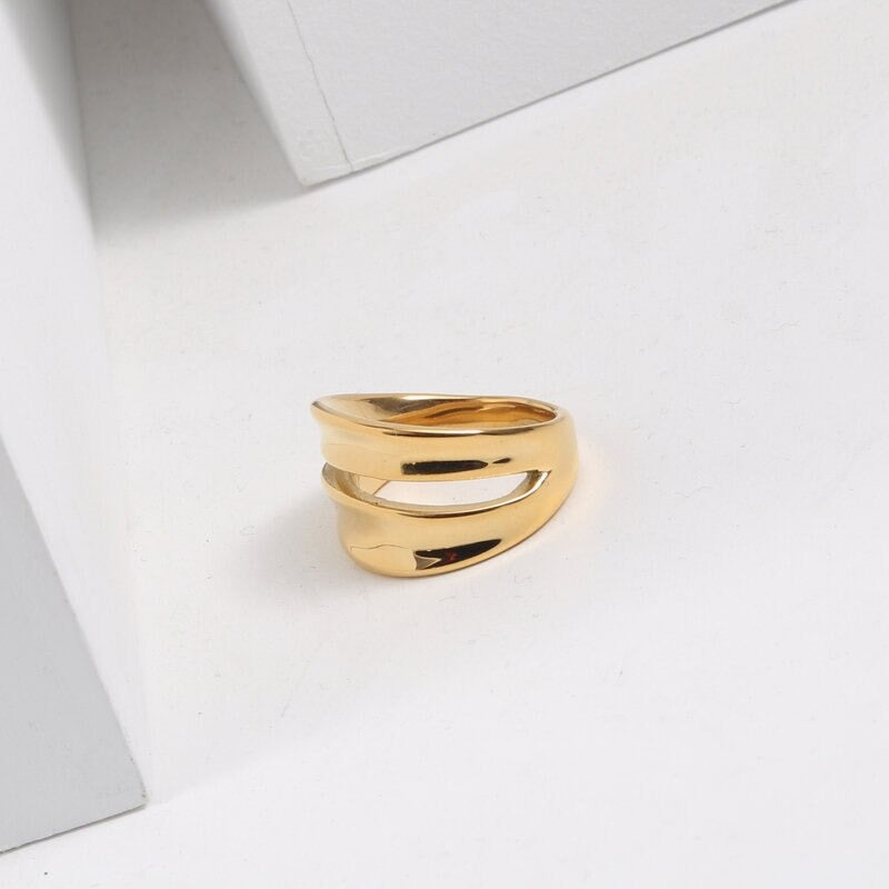 A Gold Twin Split Signet Ring shining brightly on a white background.