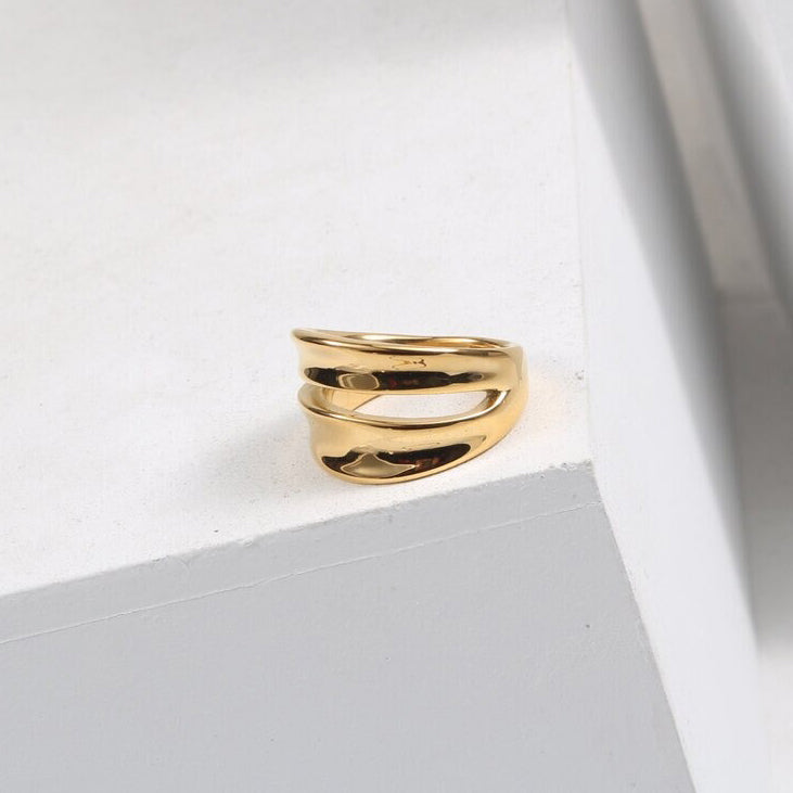A Gold Twin Split Signet Ring shining brightly on a white background.