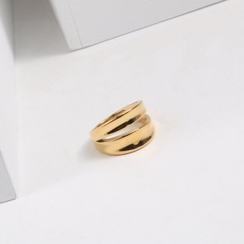 A Gold Twin Split Signet Ring shining brightly on a white background.