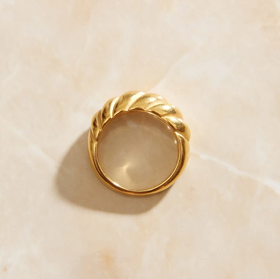 Overhead shot of a Gold Twist Signet Ring sitting on a quartz background.