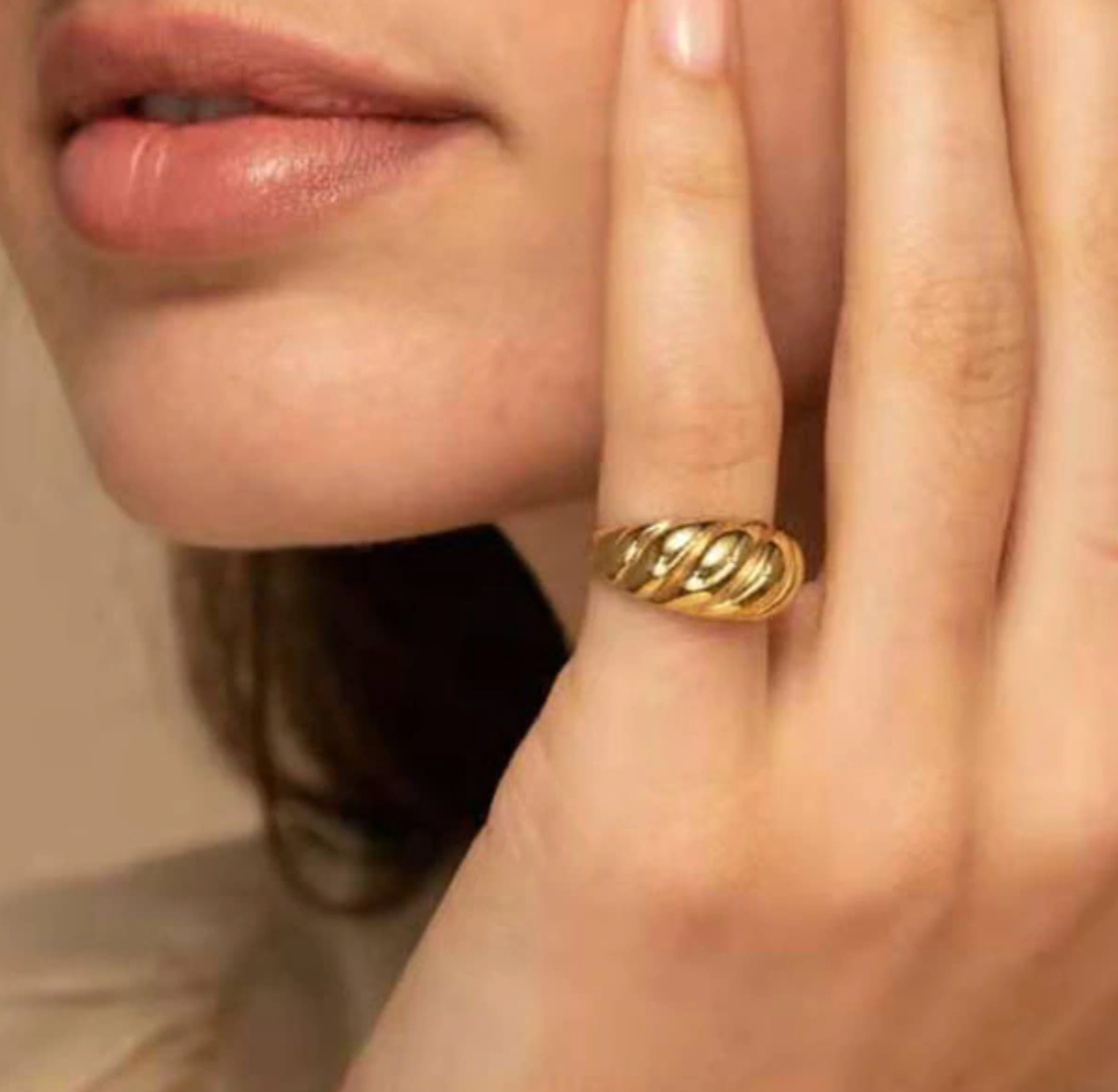 Closeup photograph of a woman's hand wearing a Gold Twist Signet Ring.