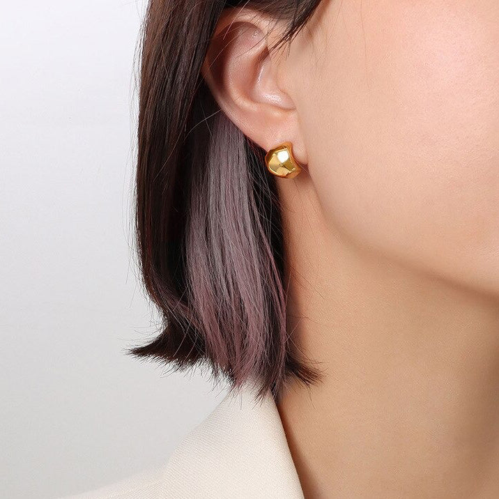 Gold Zani Faceted Earrings being worn by a woman with dark hair.