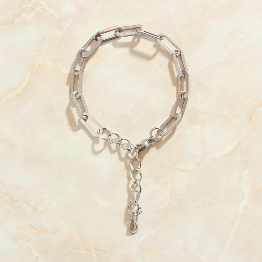Steel Long Link Bracelet on marble background.
