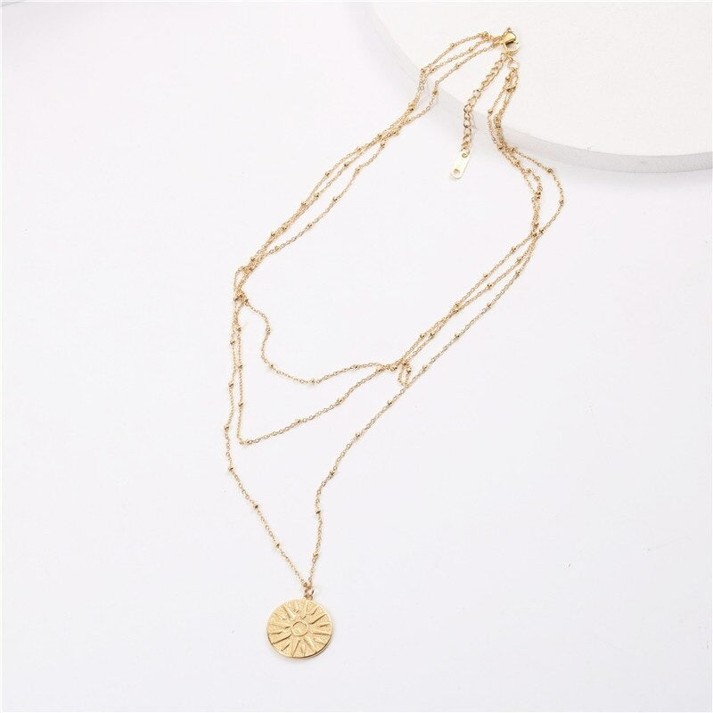 Minimalist 3 chain necklace laying on a white surface.