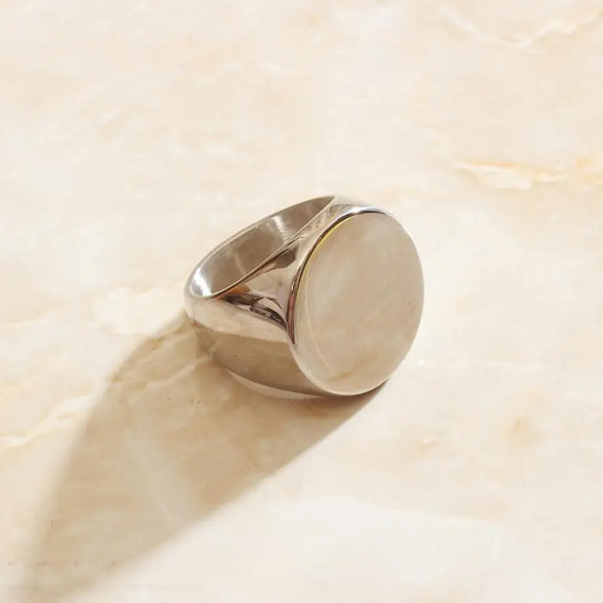 A custom silver signet ring with a round face perfect for custom engravings.